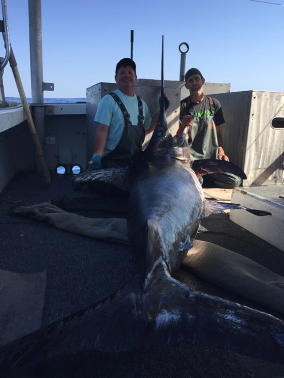 a person holding a caught fish on a boat