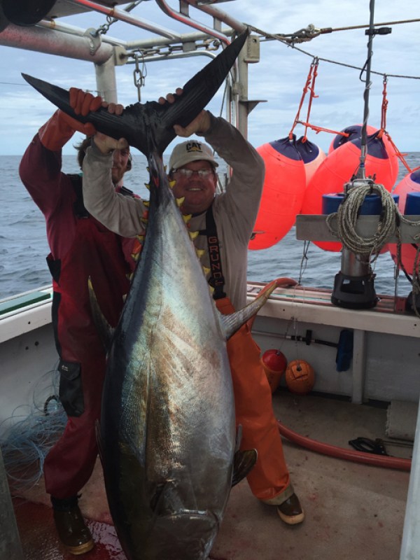 A photo of OBX Pontoon Man a person holding a caught fish on a boat
